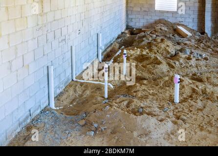 Tubi di scarico in PVC in una nuova casa nel seminterrato sistema di assemblaggio di tubi sanitari nel terreno Foto Stock