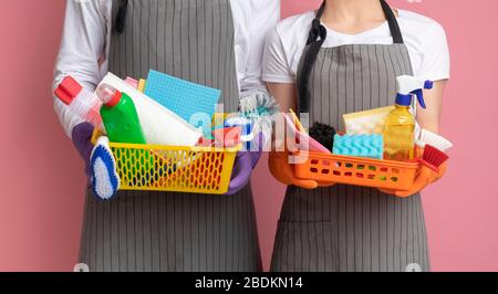 Cestini con forniture per la pulizia e utensili in mano di coppia irriconoscibile Foto Stock