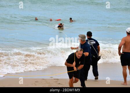 Melbourne Beach, Florida, Stati Uniti. Aprile 8, 2020. Brevard County Ocean Rescue con Brevard County Fire Rescue, ha salvato tre persone dall'Oceano Atlantico a sud di Melbourne Beach. Tutti e tre sono stati controllati dal personale di soccorso e nessuno ha richiesto ospedalizzazione. La maggior parte delle spiagge della Florida sono chiuse al pubblico a causa della pandemia di coronavirus, ma questo incidente è accaduto di fronte al loro complesso condominiale oceanside. Credito fotografico: Julian Leek/Alamy Live News Foto Stock