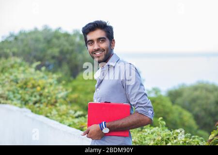 Studente indiano. Foto di primo piano di attraente, bello imprenditore sorridente. Espressione positiva del volto delle emozioni umane. La persona in camicia isolato Foto Stock