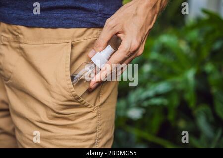 l'uomo ha messo un gel igienizzante della mano nella sua tasca dei pantaloni quando sta andando andare fuori durante la crisi dell'epidemia del corovid -19, prenda la cura della salute personale Foto Stock