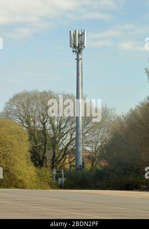 Nascosto in un angolo di un parcheggio auto il telefono cellulare mas torreggiante si trova in un proprio piccolo composto sicuro. Foto Stock