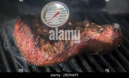 Isolato primo piano di una deliziosa carne di manzo Picanha torrefazione su una griglia calda con un indicatore di temperatura - Israele Foto Stock