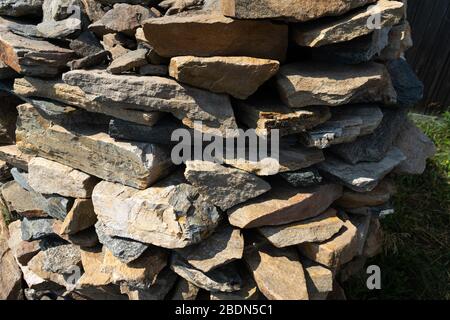 Pietra flagstone naturale impilata in un mucchio. Pietra di pietra naturale flagstone, posata in file irregolari. Sfondo della pietra di bandiera Foto Stock