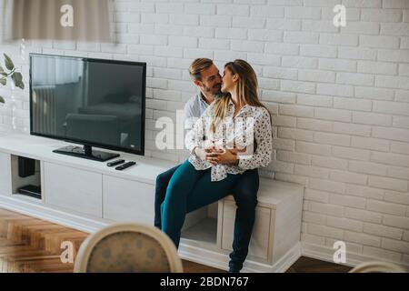 Giovane coppia felice che guarda il tablet digitale nel soggiorno Foto Stock