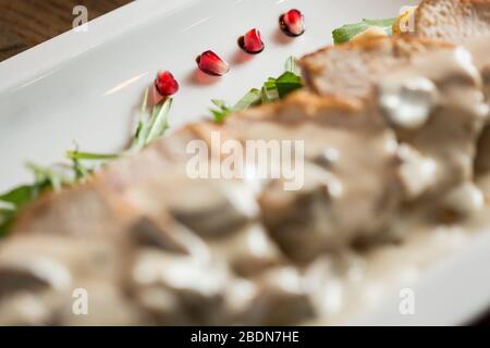 Pollo su gnocchi grattugiati in salsa di funghi e formaggio affumicato sul tavolo Foto Stock