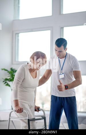 Istruttore professionista serio che tiene la sua paziente femminile Foto Stock