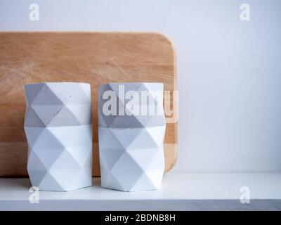 Vaso Cactus. Pentola di calcestruzzo. Due piantatrici vuote per calcestruzzo su scaffale in legno bianco isolate su sfondo bianco con spazio per copia. Foto Stock