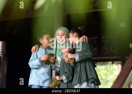 Famiglia musulmana, i bambini hanno ricevuto pacchetti di denaro come benedizione, Hari Raya Eid al-Fitr concetto. Foto Stock