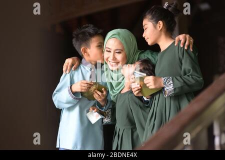 Famiglia musulmana, i bambini hanno ricevuto pacchetti di denaro come benedizione, Hari Raya Eid al-Fitr concetto. Foto Stock