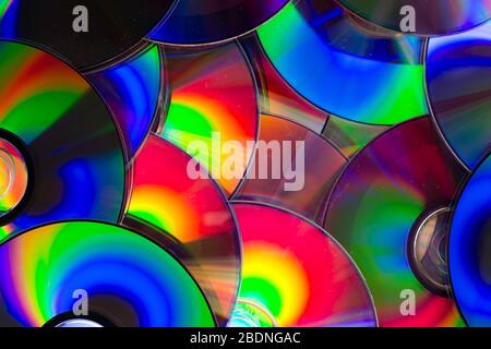 Gruppo di supporti di memorizzazione per dischi ottici CD DVD compatti con polvere e graffi. Spettro arcobaleno di colori iridescenti Foto Stock