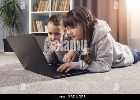 Due bambini che utilizzano computer portatile Foto Stock