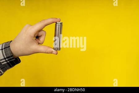 primo piano della batteria su sfondo giallo Foto Stock