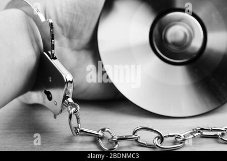 Simbolo di giustizia mano con manette e CD dati Foto Stock