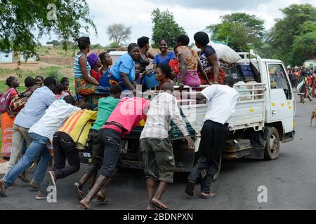 Zambia, Sinazongwe, mercato rurale nel villaggio, uomini spingere un camion mini guasto sovraccarico di donne gruppo / SAMBIA, Sinazongwe Distrikt, laendlicher Markt an einer Strasse im Dorf Foto Stock