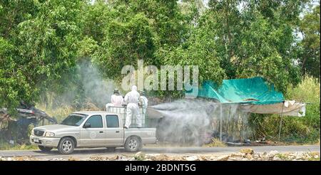 Uomo in tute bianche spray detergente per alcol. Foto Stock