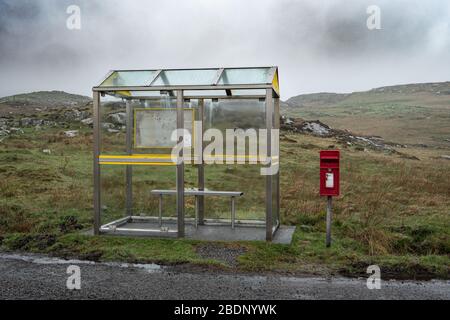 Un rifugio remoto per autobus e fermata con una cassetta postale nelle vicinanze. Barra, le Ebridi esterne, Scozia, Regno Unito. Foto Stock