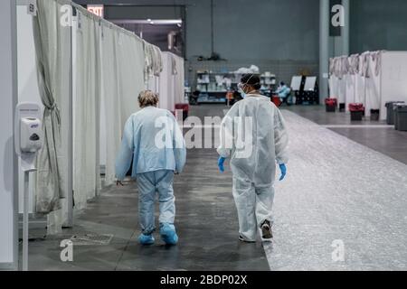 NEW YORK, USA - 07 Aprile 2020 - UN soldato assegnato a Javits New York Medical Station (JNYMS) cammina con un paziente che si sta riprendendo da COVID-19 in Foto Stock