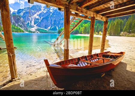 Barca in legno sotto le barche casa sul lago di Braies in paesaggio alpino, Alto Adige regione del nord Italia Foto Stock