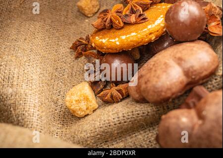 Badian, biscotti, cioccolato, torte al cioccolato e bagel su uno sfondo di tessuto omespun grossolano. Primo piano Foto Stock