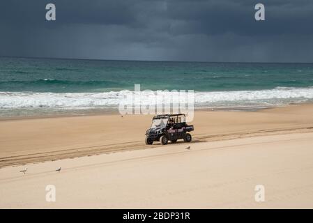 Una macchina di polizia pattuglia una spiaggia chiusa al Paradise.Council Surfers ha preso un passo straordinario di chiudere alcune spiagge della Gold Coast come misura preventiva contro la diffusione di Coronavirus dopo che migliaia di persone ignorate le regole di distanza sociale. Le spiagge dello Spit, Surfers Paradise e Coolangatta saranno chiuse da mezzanotte. Le altre spiagge della città resteranno aperte per le persone che potranno allenarsi, nuotare o fare surf, ma il Consiglio dice che non esiterà a chiudere più spiagge se la gente continuerà a rispettare le regole. Foto Stock