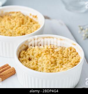 Primo piano mela crumble con streusel. Vista laterale. Colazione al mattino su tavolo grigio chiaro. Foto Stock