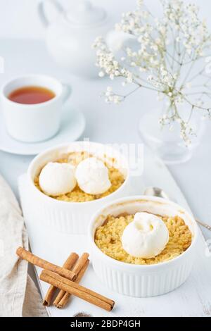 Mela crumble con streusel, tè, cannella su un tavolo grigio chiaro. Verticale. Foto Stock