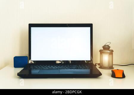 Ambiente di lavoro domestico. Lavoro da casa. Notebook, altoparlante bluetooth e bella lampada sul tavolo. Freelance, lavoro a casa o concetto di quarantena. Foto Stock