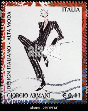 Abito da donna disegnato da Giorgio Armani su francobollo italiano Foto Stock