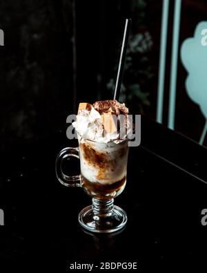 Bere caffè con panna montata e cookie Foto Stock