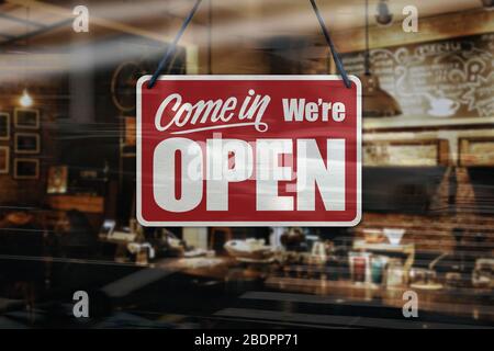 Un cartello commerciale che dice "come in We're Open" sulla finestra del Cafe / Restaurant. Foto Stock