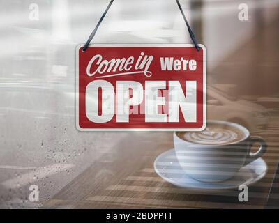 Un cartello commerciale che dice "come in We're Open" sulla finestra del Cafe / Restaurant. Foto Stock