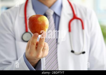 Medicina maschile medico terapeutico mani tenendo rosso fresco mela matura Foto Stock