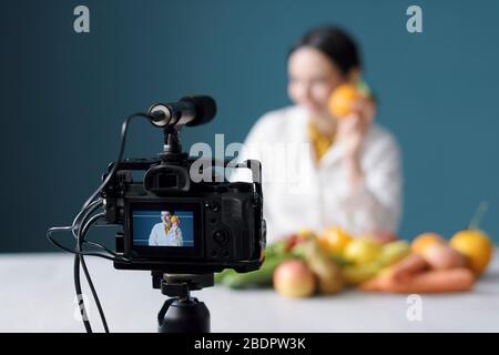 Nutrizionista femminile professionista che parla di dieta sana e di fare un video blog Foto Stock