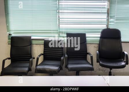 Poltrona nera accanto alla finestra nella sala conferenze del piccolo ufficio. Foto Stock