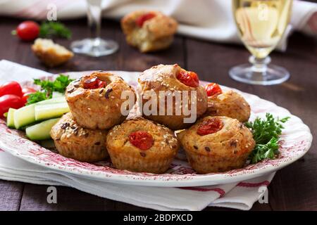 Muffin con formaggio, formaggio casolare e pomodori, verdure e formaggi serviti con vino. Foto Stock