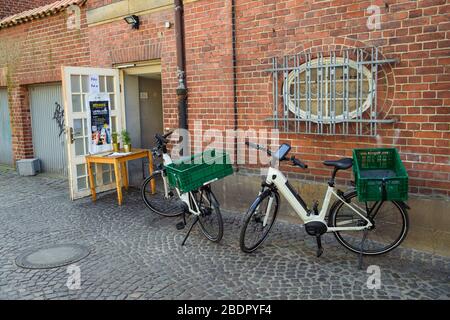 09 aprile 2020, Schleswig-Holstein, Lübeck: Le biciclette elettriche sono disponibili per i conducenti all'ingresso posteriore di un servizio di consegna. Foto: Gregor Fischer/dpa Foto Stock