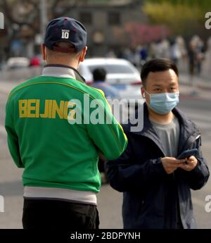 Pechino, Cina. 9 aprile 2020. I cinesi indossano maschere protettive per il viso godono del clima caldo a Pechino il giovedì 9 aprile 2020. La capitale cinese sta rallentando il ritorno alla vita "normale" dalle misure di sicurezza draconiane a causa dell'epidemia di Covid-19, mentre il governo solleva lentamente alcune restrizioni sui viaggi e sulle interazioni sociali. Foto di Stephen Shaver/UPI Credit: UPI/Alamy Live News Foto Stock