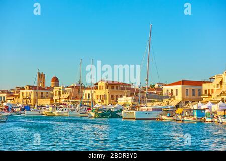 Barche e barche nel porto e lungomare di Egina città al tramonto, Isola di Egina, Grecia Foto Stock