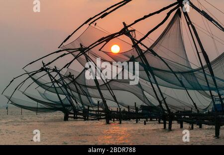 Le famose reti da pesca cinesi di Kochi (Cochin) sul lato Vepeen del porto circa essere abbassato ad alta marea, Kerala, India Foto Stock