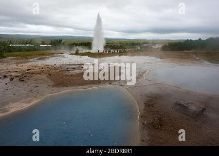 Una piscina blu calda di fronte ai geyser a Geysir in Islanda Foto Stock