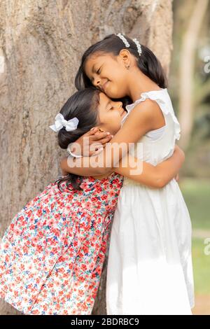 Piccole sorelle teneri che si abbracciano e mostrano il loro vero amore Foto Stock