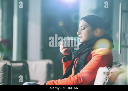 Donna attraente di relax presso il cafe e bere un caffè caldo Foto Stock