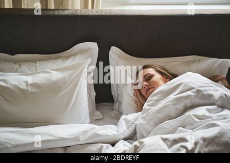 Moderna e tranquilla, giovane donna che dorme in pace Foto Stock