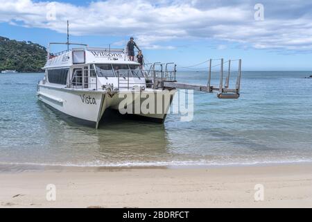 KAITERITERI, NUOVA ZELANDA - Novembre 15 2019: Nave turistica passeggeri che atterra sulla sabbia a Little Medlands Beach Inlet, girato in luce di primavera brillante su Foto Stock