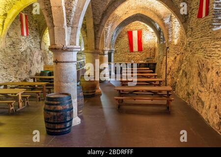 Sala da pranzo in volta medievale ad arco con mobili e colonne Foto Stock