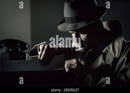 Vintage undercover spy penale Furto di file in un archivio a tarda notte, sicurezza e il furto di dati concept Foto Stock