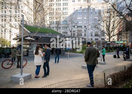 I commensali allo Shake Shack nel Madison Square Park di New York praticano pazientemente il distanziamento sociale mentre attendono i loro ordini di take-out sabato 4 aprile 2020. (© Richard B. Levine) Foto Stock