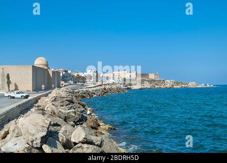 Fronte mare con Grande Moschea di Mahdiya in primo piano e Borj el Kebir il Forte Ottomano in distanza, Mahdia, Tunisia Foto Stock