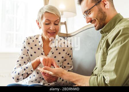 Soothsayer femminile guardando i suoi clienti Palm Foto Stock